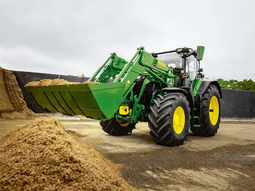 Godet d’un chargeur frontal rempli d’ensilage sur un tracteur John&nbsp;Deere lors d’opérations de manutention.