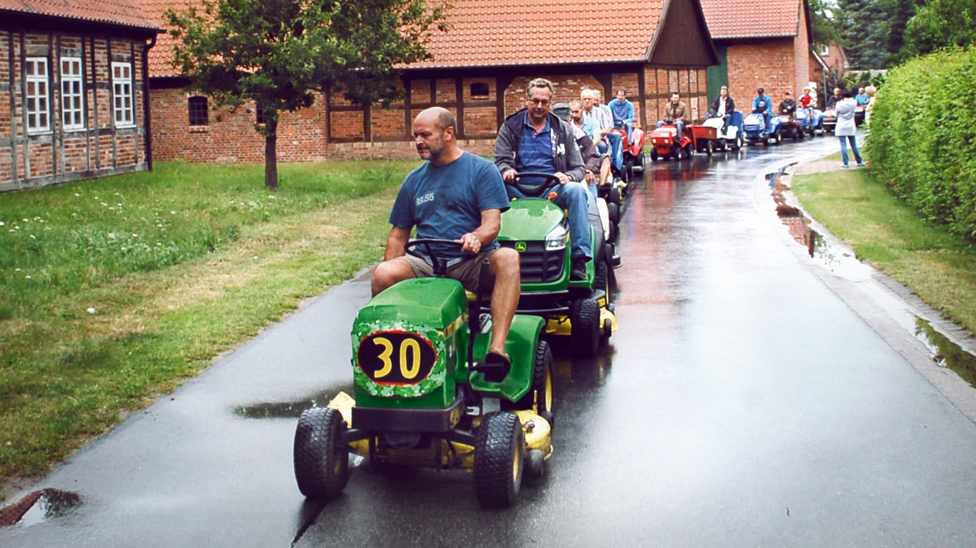 Oude zitgazonmaaier, huiseigenaar, dorp, parade