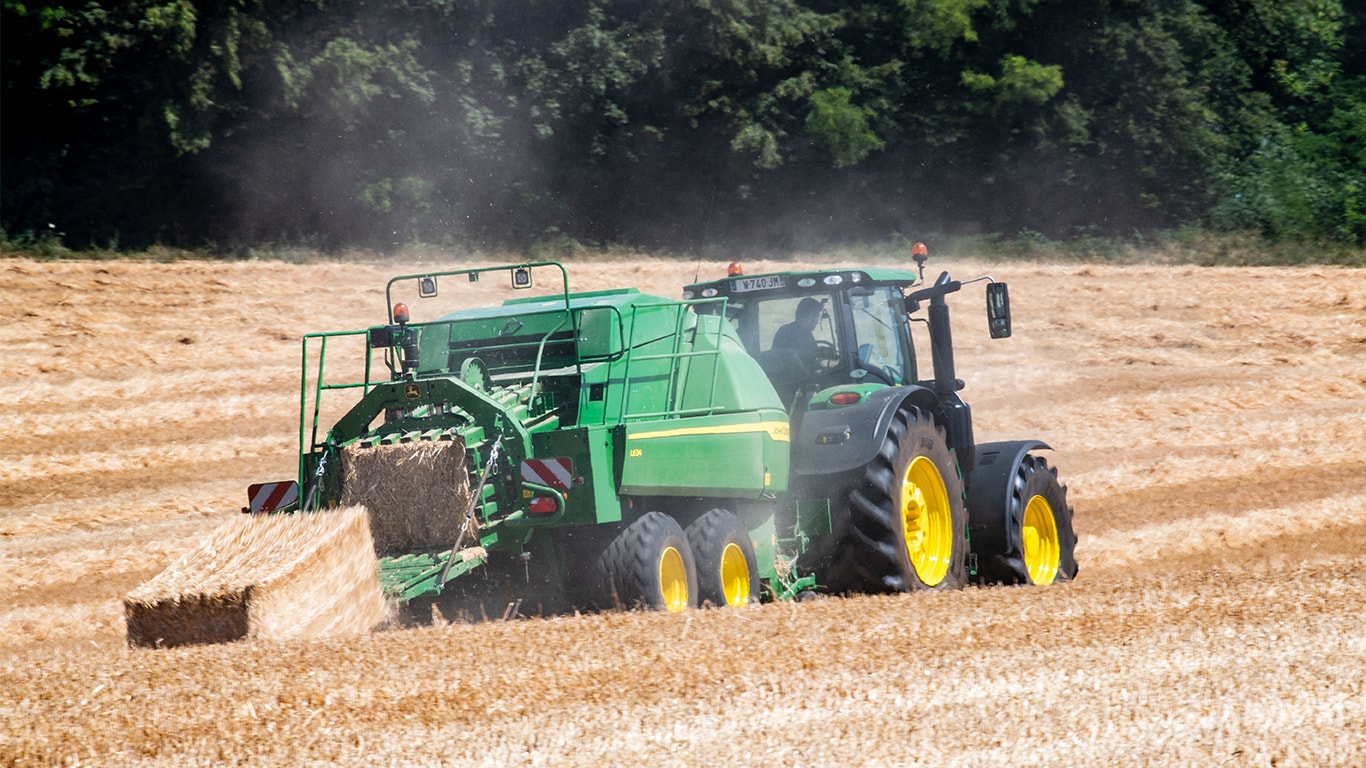 Presse haute densité L634 John Deere avec tracteur 6R en conditions de paille