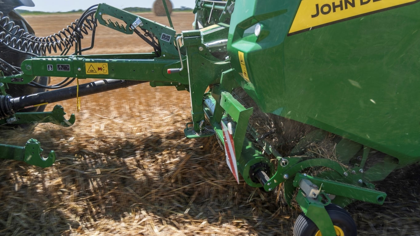 Le ramasseur haute capacité d’une presse à balles VR John Deere absorbant un énorme andain de paille