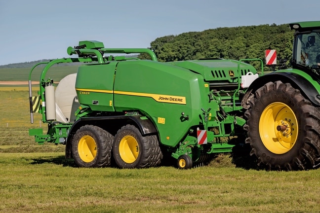 Presse enrubanneuse John Deere C442R formant des balles d’ensilage à haute densité
