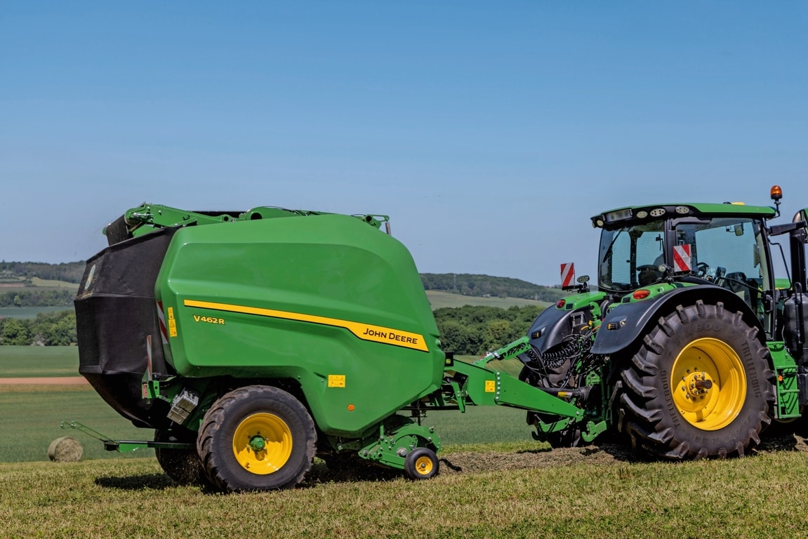 John Deere V462R tirée par un tracteur John Deere 6R 185 pressant du foin